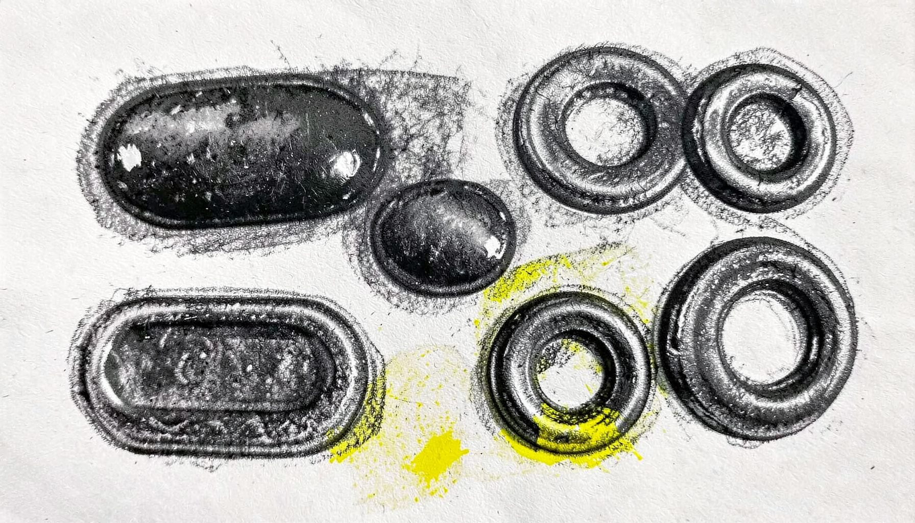 A bold charcoal drawing of glossy buttons in various shapes — pill, rounded rectangle, and circle — with subtle shadows and highlights