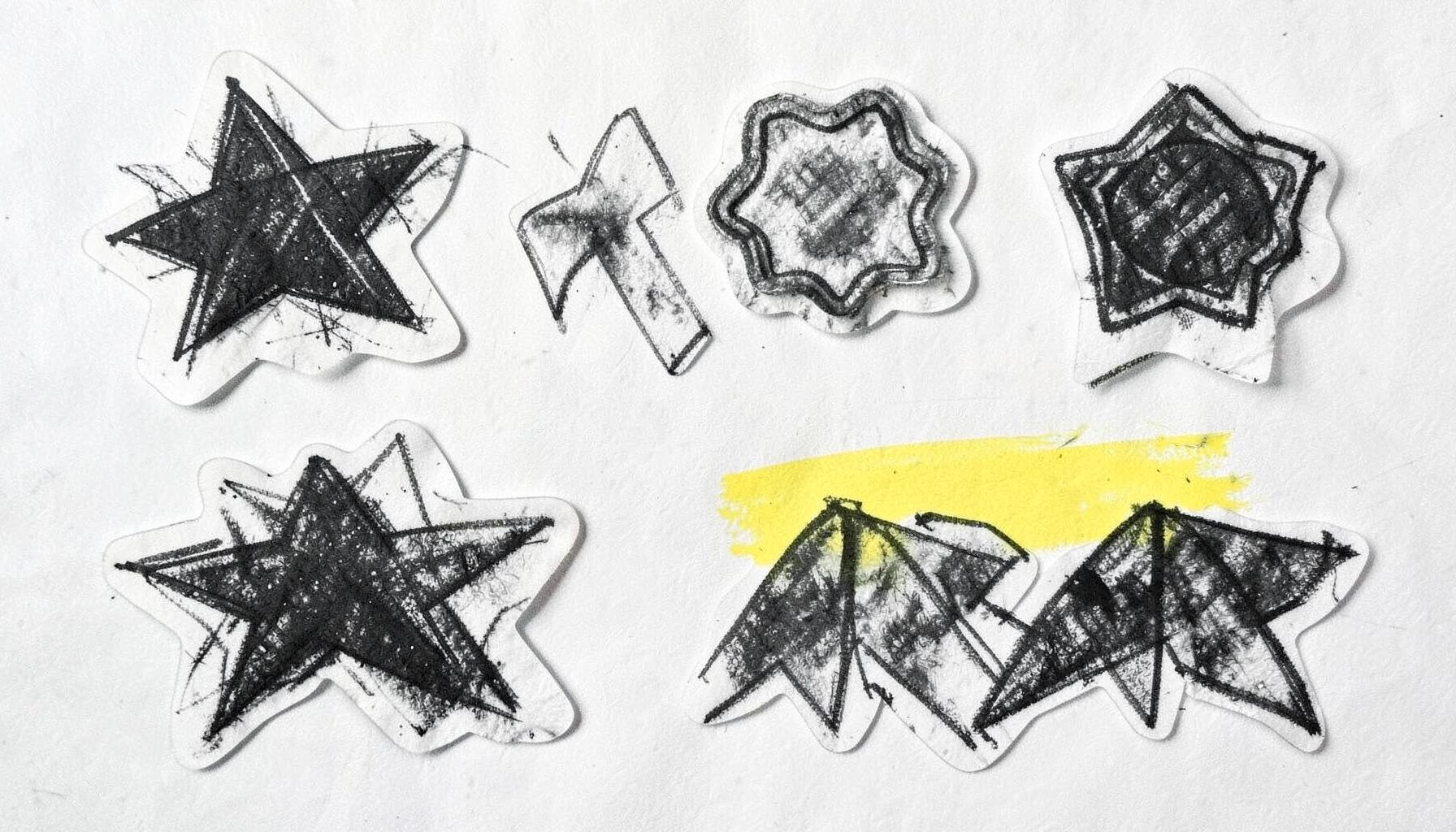 A bold charcoal sketch of peel-off sticker shapes — stars, badges, and ribbons — with curled edges and soft drop shadows